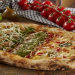 Pizza Oval: 1/3 Margherita, 1/3 Pesto, 1/3 Mussarela, rúcula, parma e figo, com raspas de parmesão